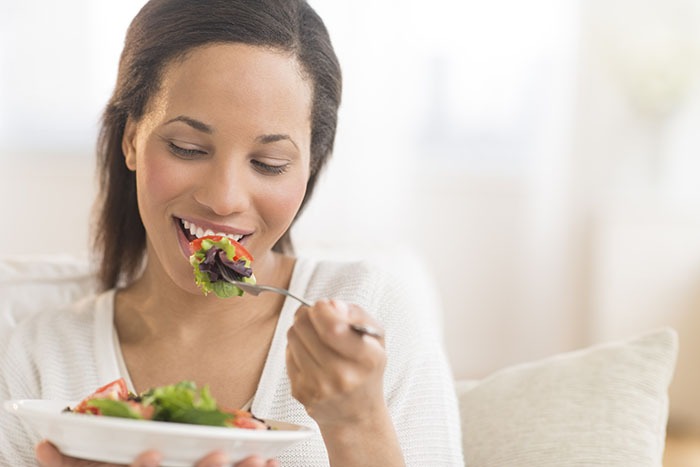 fille qui mange en souriant