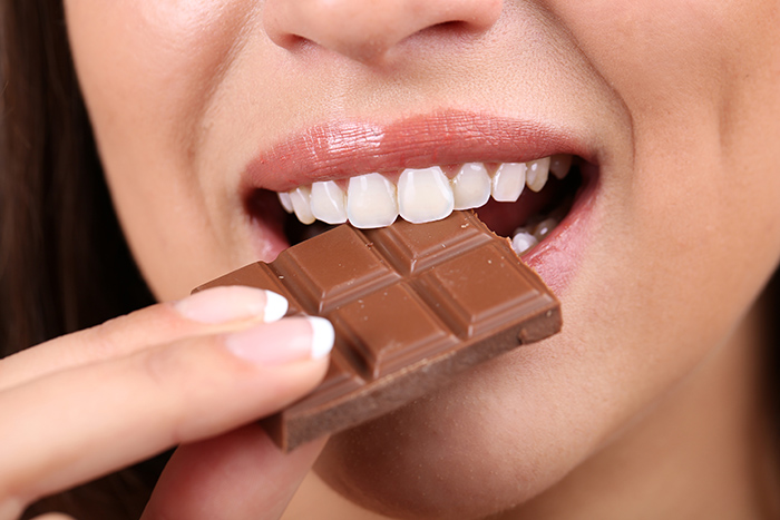 fille qui croque dans du chocolat