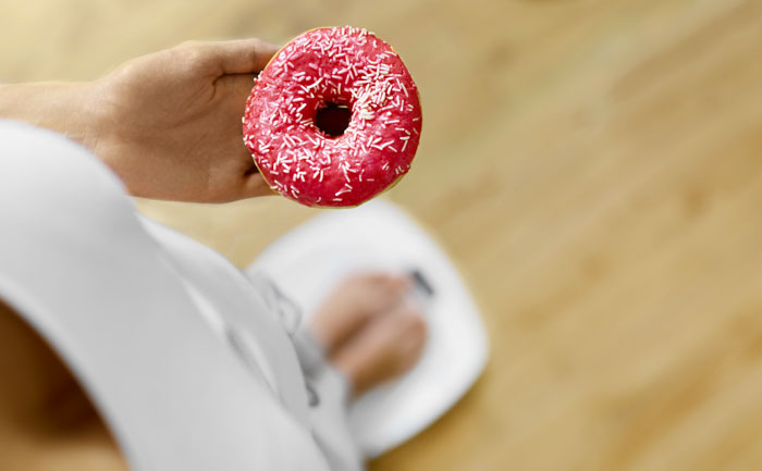femme sur une balance qui tient un donut