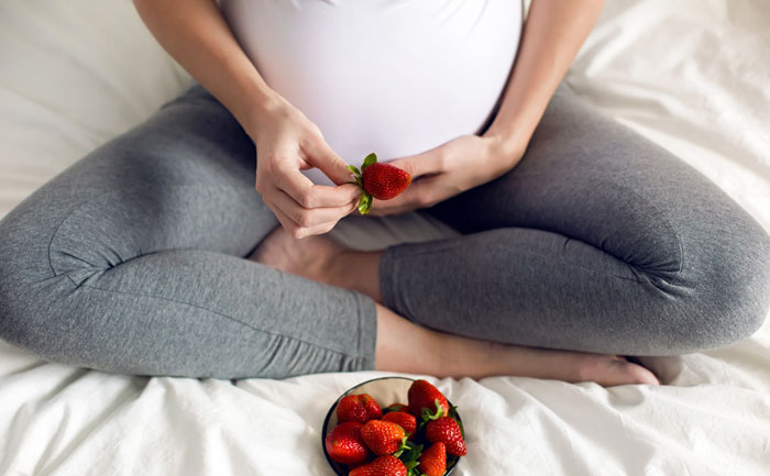 Une femme enceinte qui mange des fraises
