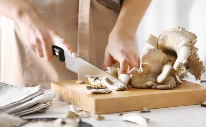 Femme en train de cuisiner des champignons